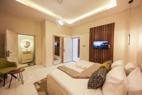 a bedroom with a bed and a tv on a wall at George Residence Osapa, Lekki in Lekki