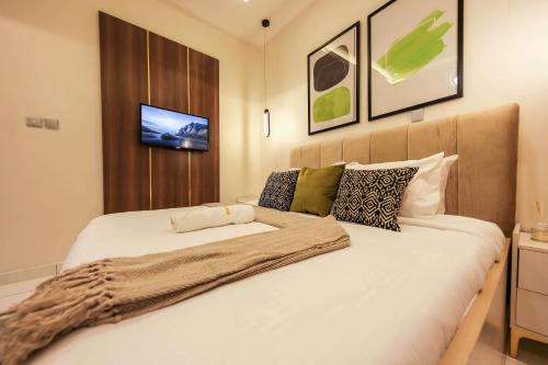 a bedroom with a bed with white sheets and a tv at George Residence Osapa, Lekki in Lekki