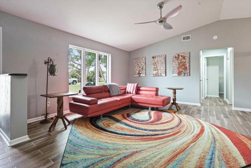 a living room with a red couch and a rug at Charming Luxury Heated Pool Home in Cape Coral