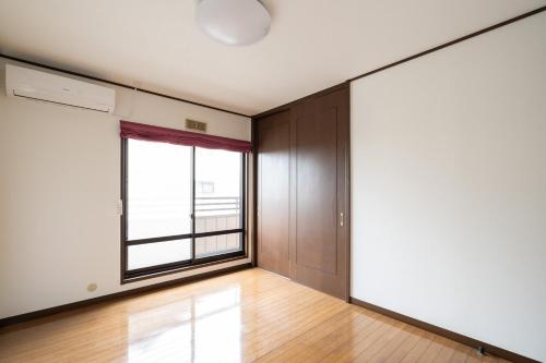 an empty room with a large window and wooden floors at Hamanoakariya Kujukuri in Katakai