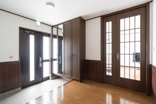 a hallway with wooden doors and windows in a building at Hamanoakariya Kujukuri in Katakai