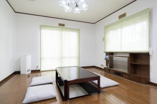 a living room with a glass table and a couch at Hamanoakariya Kujukuri in Katakai