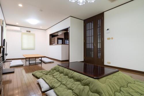 a large green couch in a room with a table at Hamanoakariya Kujukuri in Katakai