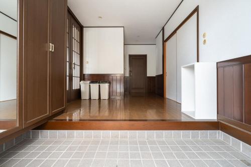 an empty hallway with wooden doors and a tile floor at Hamanoakariya Kujukuri in Katakai