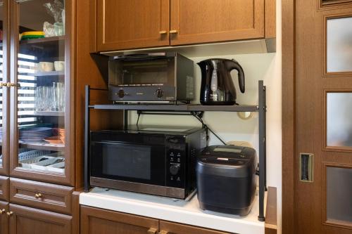 a kitchen with a microwave and a coffee maker at Hamanoakariya Kujukuri in Katakai