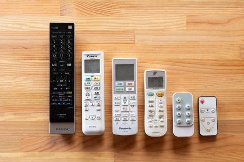 a group of remote controls lined up on a table at Hamanoakariya Kujukuri in Katakai