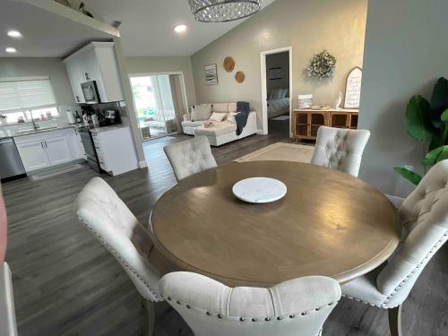 珊瑚角Pelican House 4 bedrooms Free Heated Pool的客厅配有木桌和白色椅子