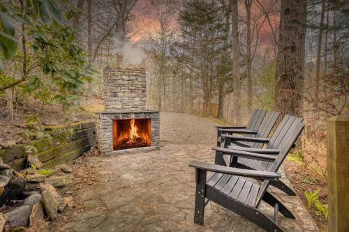 two benches sitting next to a fireplace in the woods at Secluded Sunrise Ridge-10 Min From Blue Ridge, King Beds, Hot Tub, 2 Porches, Fireplace Wood Burning, Mountain View, Cozy in Blue Ridge
