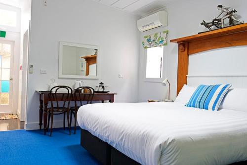 a bedroom with a bed and a table and a desk at The Old Oak Boutique Hotel in Mangonui