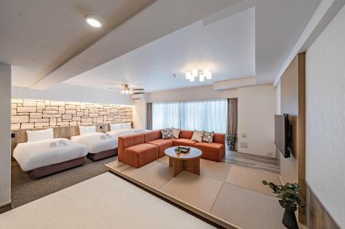 un ampio soggiorno con divano e TV di Apartment Hotel 11 Namba Motomachi ad Osaka