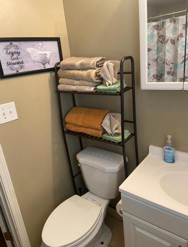 a bathroom with a toilet and a towel rack next to a sink at 3 bedroom Cozy vacation rental near airport in Kenner