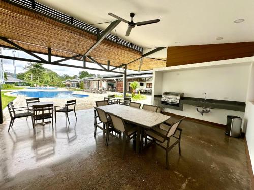 a dining room with a table and chairs and a pool at Viva Jaco 9-05 in Jacó
