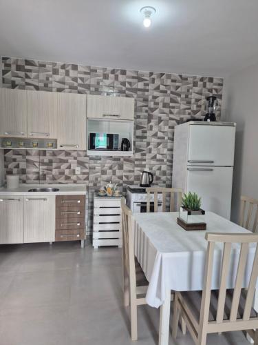 ゴヴェルナドール・セウソ・ラーモスにあるCasa Pescadorのテーブルと白い冷蔵庫のあるキッチン