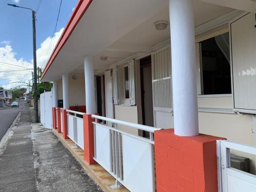 a building with red and white pillars on a street at Le Rialdys in Le Moule