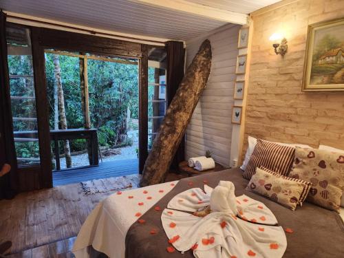 a bedroom with a bed and a large window at Chalé Tinyhouse Com hidromassagem in Campos do Jordão