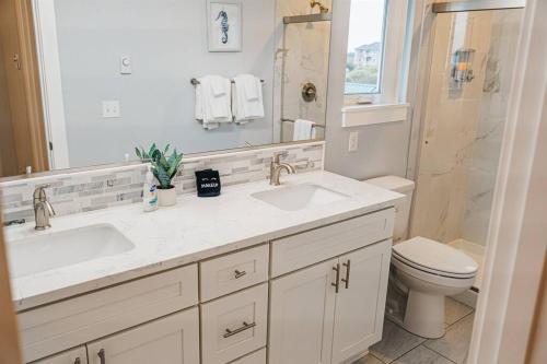 une salle de bain avec deux lavabos et un WC et un miroir dans l'établissement Oceans3 - Spectacular View 'N' Jetty Access, à Ocean Shores