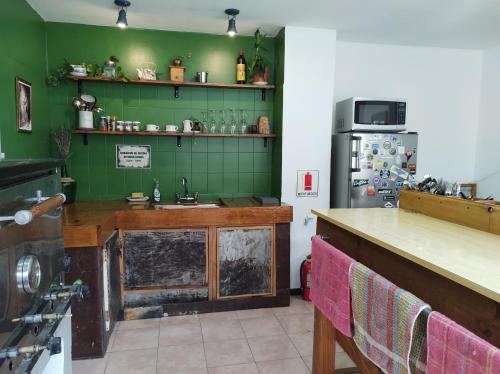 una cocina con fregadero y refrigerador en Hostel Yatel, en El Calafate