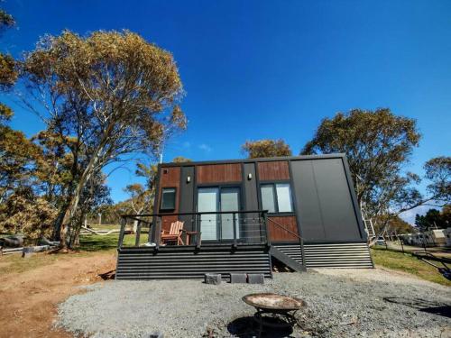 a small house on a hill with a tree at Braemar Bay Holiday Park in Kyloe