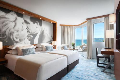 a hotel room with two beds and a large wall at JW Marriott Cannes in Cannes