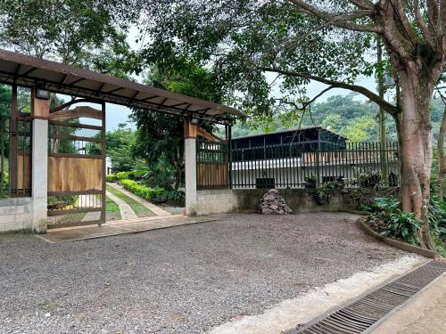 a building with a gate and a fence with a tree at La Villa de los Alas in Juayúa