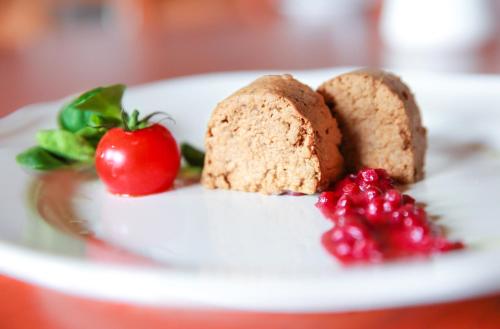 a white plate with a piece of bread and a strawberry at Hotel Koliba Greta in Liptovská Sielnica