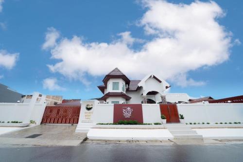 a white building with a red and white fence at The Star Pool Villa Hatyai in Hat Yai