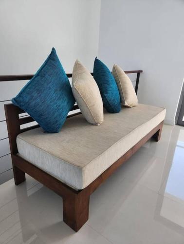 a bench with four blue pillows on it at Ocean View Condos in Galle