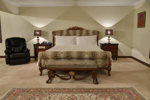 a bedroom with a bed and a chair and two lamps at Karachi Marriott Hotel in Karachi