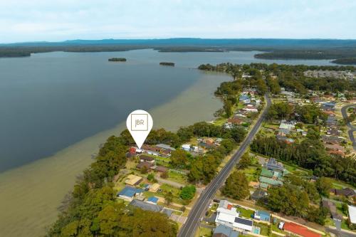an island with a hot air balloon flying over a river at Jado on the Lake - Captains Quarters in St Georges Basin