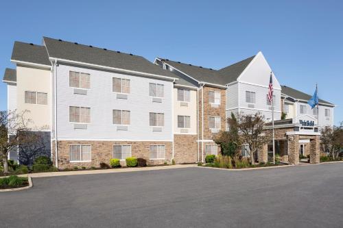 a large apartment building with a parking lot at Fairfield Inn & Suites Naperville/Aurora in Naperville