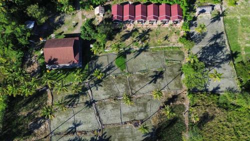 an overhead view of a yard with a building and trees at Nuna Bungalows in Riung