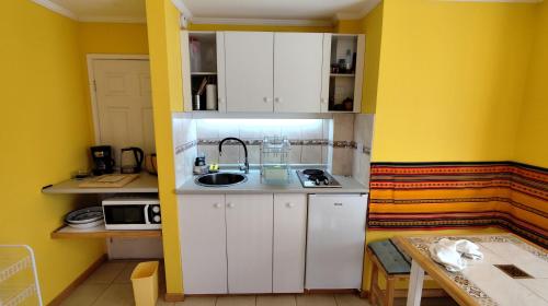 a small kitchen with white cabinets and a sink at Linda cabaña en duplex cerca de la playa de Maitencillo in Maitencillo