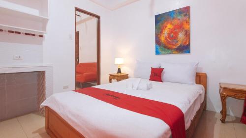 a bedroom with a bed with a red and white blanket at RedDoorz near LRT 2 Antipolo Station in Antipolo