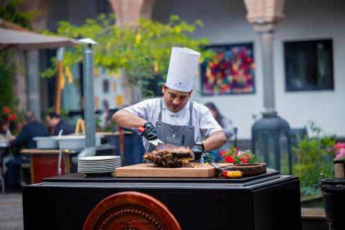 a man in a chefs hat preparing food on a table at JW Marriott El Convento Cusco in Cusco
