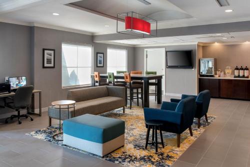 a waiting room with a couch and chairs and a table at TownePlace Suites Wilmington Newark / Christiana in Newark