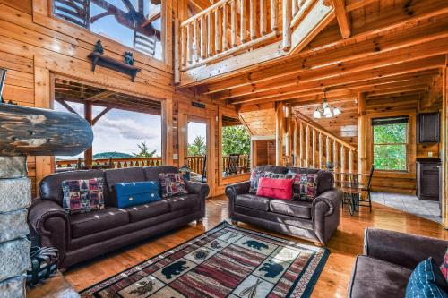 a living room with two leather couches and a fireplace at Extravagant View Cabin in Park Settlement