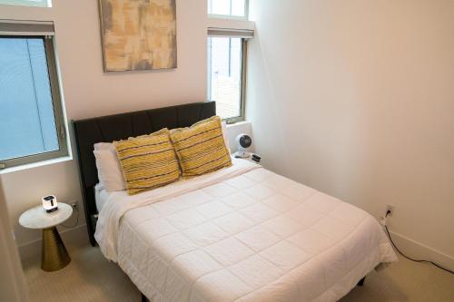 a bedroom with a large white bed with yellow pillows at Explore Seattle - Free Parking, Steps to Light Rail, Stadiums and VA in Seattle