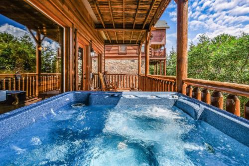 a hot tub on a porch of a house at Extravagant View Cabin in Park Settlement