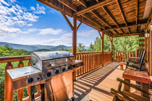a grill on the deck of a cabin with a view at Extravagant View Cabin in Park Settlement
