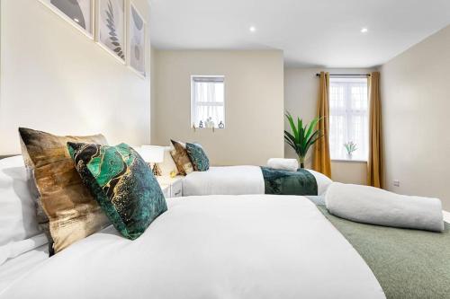 a white bedroom with two beds and a couch at Immaculate 2BR London Flat with King Bed-Parking Available-Sleeps 6-20 Percent OFF Off Long Stays! Perfect for Families, Contractors & Couples! in Barnet