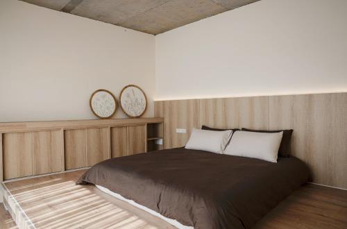 a bedroom with a bed and two clocks on the wall at Living In Light in Zhongpu