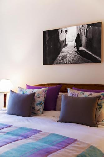a bedroom with a bed with a painting on the wall at Villa Quieta in Essaouira