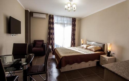 una camera con un letto e una sedia e una finestra di My Batumi Apartments a Batumi