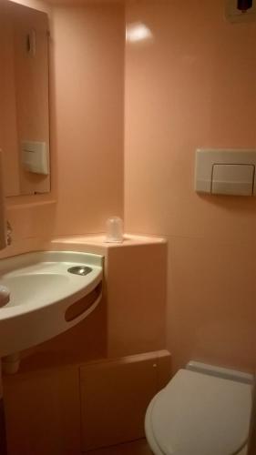 a bathroom with a white toilet and a sink at Premiere Classe Dreux in Dreux