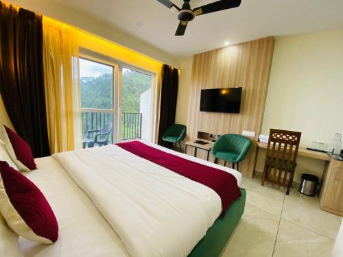 a hotel room with a bed and a desk with a computer at Hotel Pines And Peeks By Tws Hotels in Dalhousie