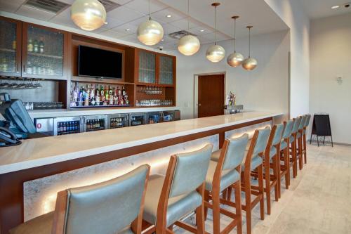 a bar with a row of chairs in a restaurant at SpringHill Suites by Marriott Dallas Plano/Frisco in Plano