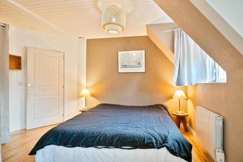 - une chambre avec un lit avec des draps bleus et deux lampes dans l'établissement The Saint-Malo Drifter - Holiday Home, à Saint-Malo