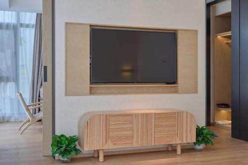 a living room with a flat screen tv on a wall at Jingdezhen Seven Bamboo Wind Over Ear Hotel in Xianghu