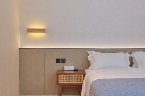 a bedroom with a bed and a nightstand next to a bed at Jingdezhen Seven Bamboo Wind Over Ear Hotel in Xianghu