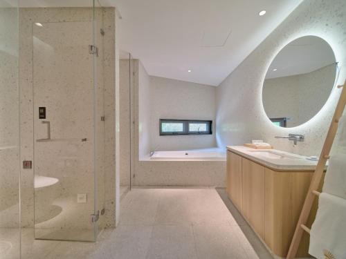 a bathroom with a tub and a sink and a shower at Jingdezhen Seven Bamboo Wind Over Ear Hotel in Xianghu